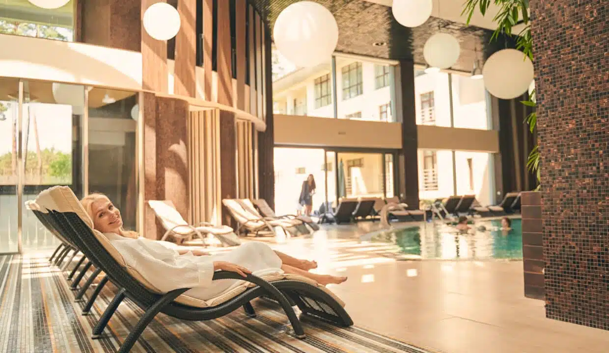 Happy adult woman lying on sun bed at luxury spa hotel