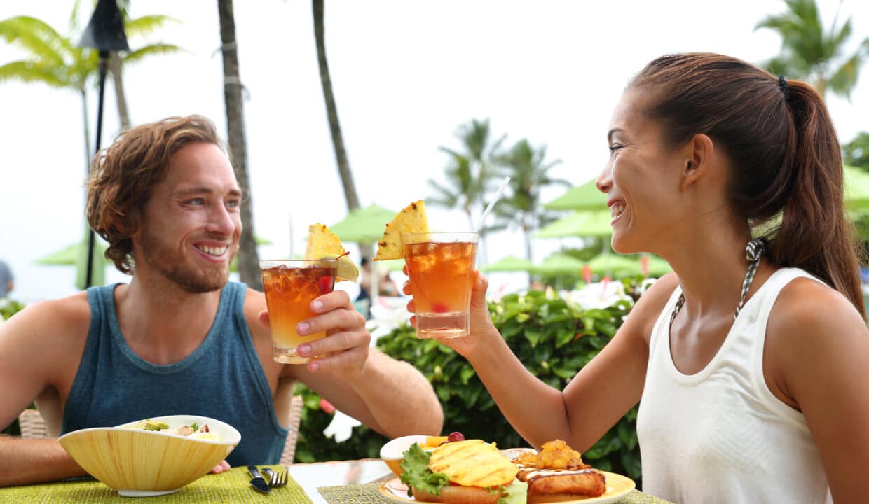 Happy,Multiracial,Couple,Toasting,Cheers,With,Alcoholic,Hawaiian,Drinks,,Mai